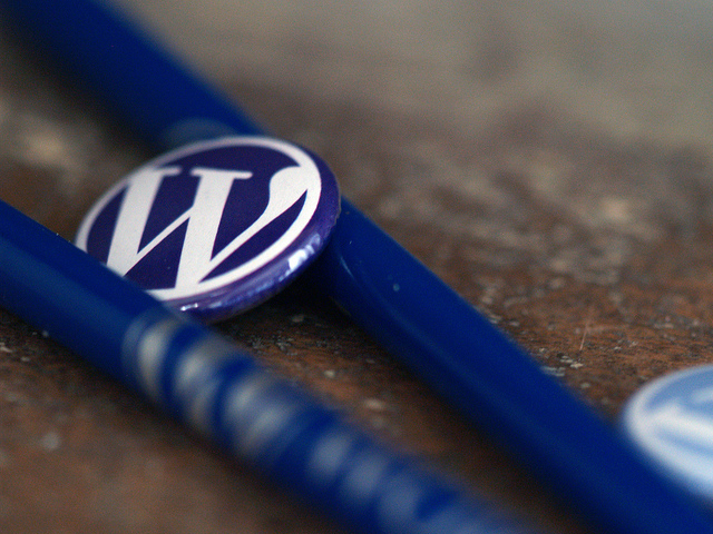 Chapa azul con logo blanco de WordPress. En medio de 2 bolis azules con la marca.Cómo hacer categorías y etiquetas en WordPress